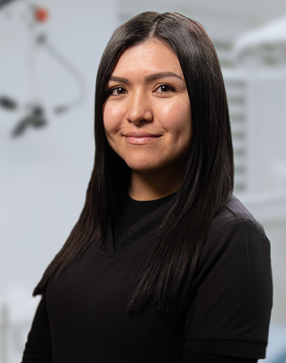 Kat, a dental assistant, smiling in a clinical setting