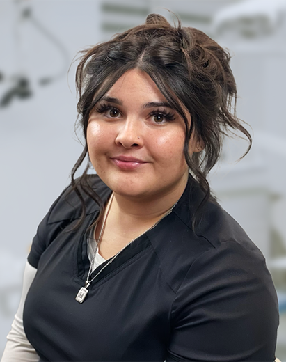 Mikenzi, a dental assistant, smiling in a dental office environment.